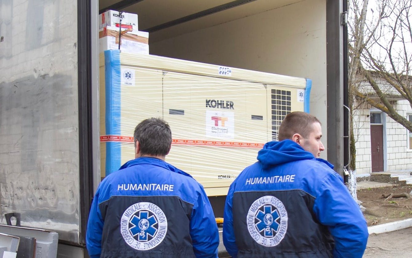 Humanitaires attendant une livraison Kohler pour l'ONG Electriciens sans frontières